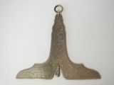 un objet ancien en forme de chaussure, plaqué argent, posé sur une surface blanche