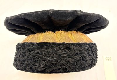 un gros plan d'un chapeau noir et jaune posé sur une surface blanche
