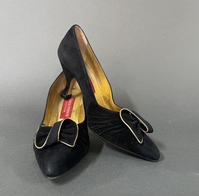 pair of women ' s black shoes with a bow on the toe
