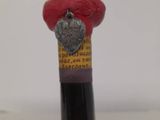 a bottle of wine with a red hat on top of it