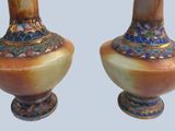 two vases that are sitting side by side on a table