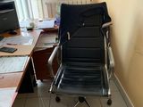 a black office chair sitting in front of a computer desk