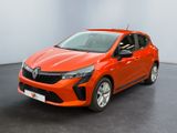 Une voiture rouge est garée dans une pièce au sol noir.