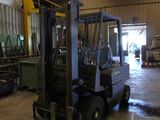 a forklift truck parked in a warehouse with lots of pallets