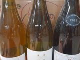 three bottles of wine sitting on a table in front of a cardboard box
