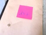 a piece of paper that has a pink sticker on it