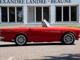 a red convertible car parked in front of a building