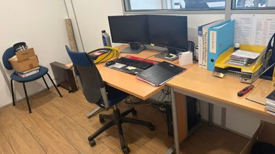 un bureau sur lequel se trouvent deux écrans d'ordinateur et un ordinateur portable