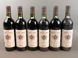 six bouteilles de vin sont alignées sur une table