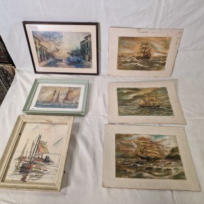 quatre photos encadrées représentant des bateaux, posées sur une table blanche