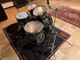 a drum set up on a rug in a music studio