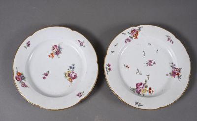 two plates with flowers on them are sitting on a table