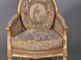 an old chair with a tapestry on the back of it