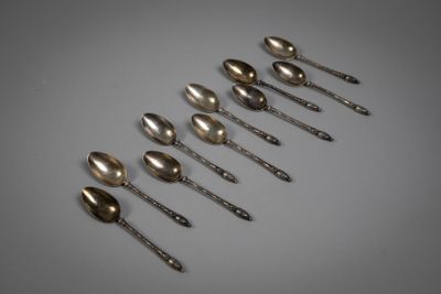 six silver spoons are lined up in a row on a table