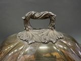 a large silver vase with a handle on a table