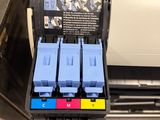 a printer with four ink cartridges sitting on top of it