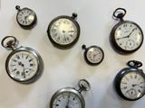 many different types of clocks displayed on a white surface