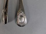 two spoons and a spoon rest next to each other on a table