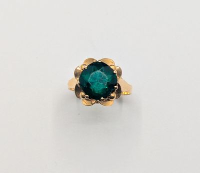 a close up of a ring with a green stone in it