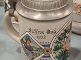 a beer mug sitting on a table next to other mugs
