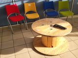brightly colored chairs and a table in a waiting room with a remote control on it