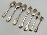 six silverplated spoons and a fork are lined up on a table