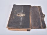 an old book that is open on a white table