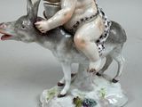 a figurine of a boy riding on a donkey
