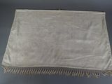 a white table cloth with fringes hanging from it ' s sides