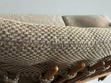 a close up of a couch with a wooden frame