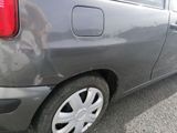 a small gray car parked in a parking lot