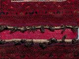 an image of a red and black rug sitting on top of a wooden table