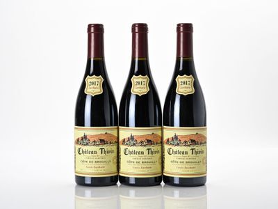 trois bouteilles de vin rouge posées côte à côte sur une table