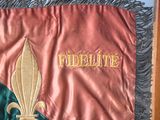 a red and green flag with a gold fleur de lis on it