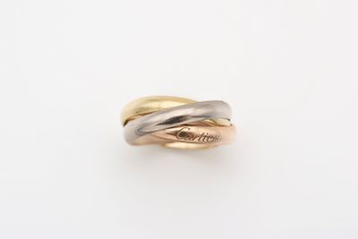 gros plan d'une bague en or et en argent sur une surface blanche