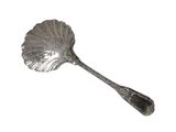 une cuillère en argent ornée d'une feuille, posée sur un fond blanc
