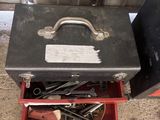 une boîte à outils contenant des outils, posée sur le sol