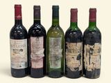 six bottles of wine are lined up in a row on a white surface