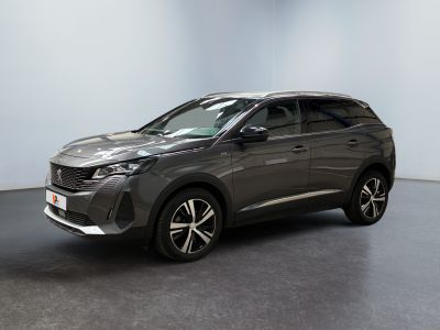 Un SUV gris est garé dans une pièce au sol noir.
