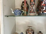 de nombreux vases différents sur les étagères de cette vitrine