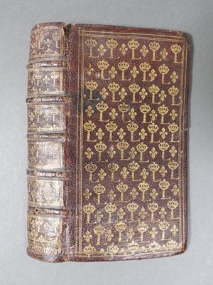 an old book with ornate designs on it sitting on top of a table