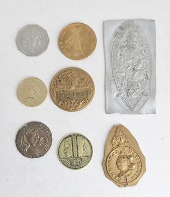 some coins are sitting on top of a white surface next to a bag
