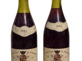 two bottles of wine sitting next to each other on a white surface
