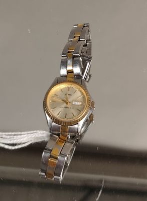 une montre en argent et en or suspendue à un bracelet en argent et en or