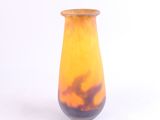 un vase jaune et noir posé sur une surface blanche