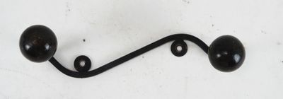 a black metal hook with two black balls on it