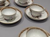 many cups and saucers sitting on a table