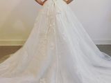 a woman in a wedding dress standing in front of a white wall