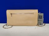 a beige purse with a chain around it and a tag attached to it