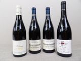 four bottles of wine are lined up on a table
